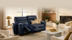 Plush navy leather recliner sofa with footrest extended in a cozy living room